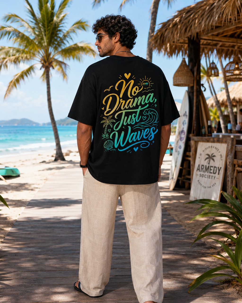 Tricou negru oversized No Drama Just Waves cu grafica mare pe spate, purtat in decor tropical